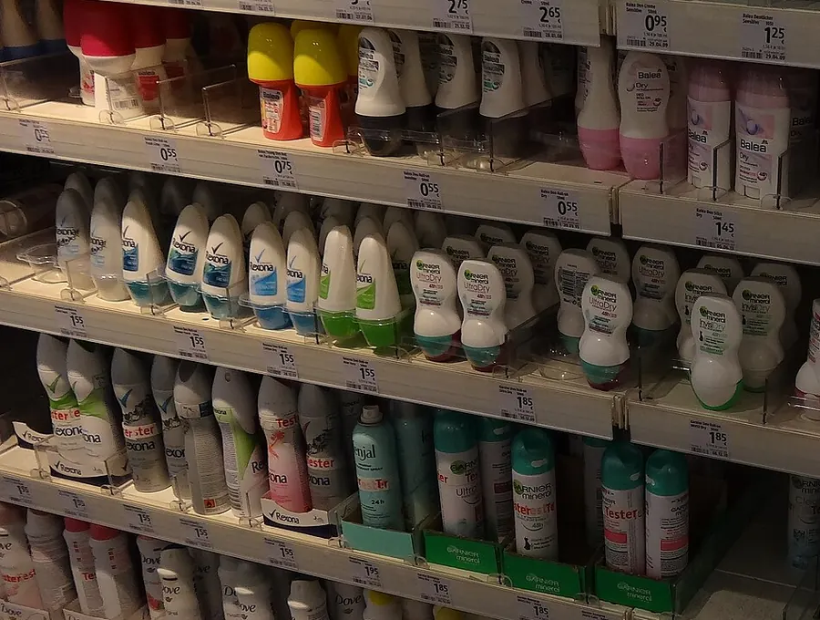 Retail shelving filled with rows of deodorant and antiperspirant sticks and sprays.