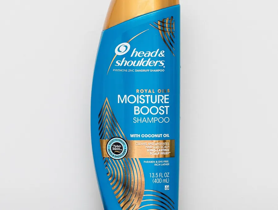 Bottle of Head & Shoulders Moisture Boost anti-dandruff shampoo standing on a counter.