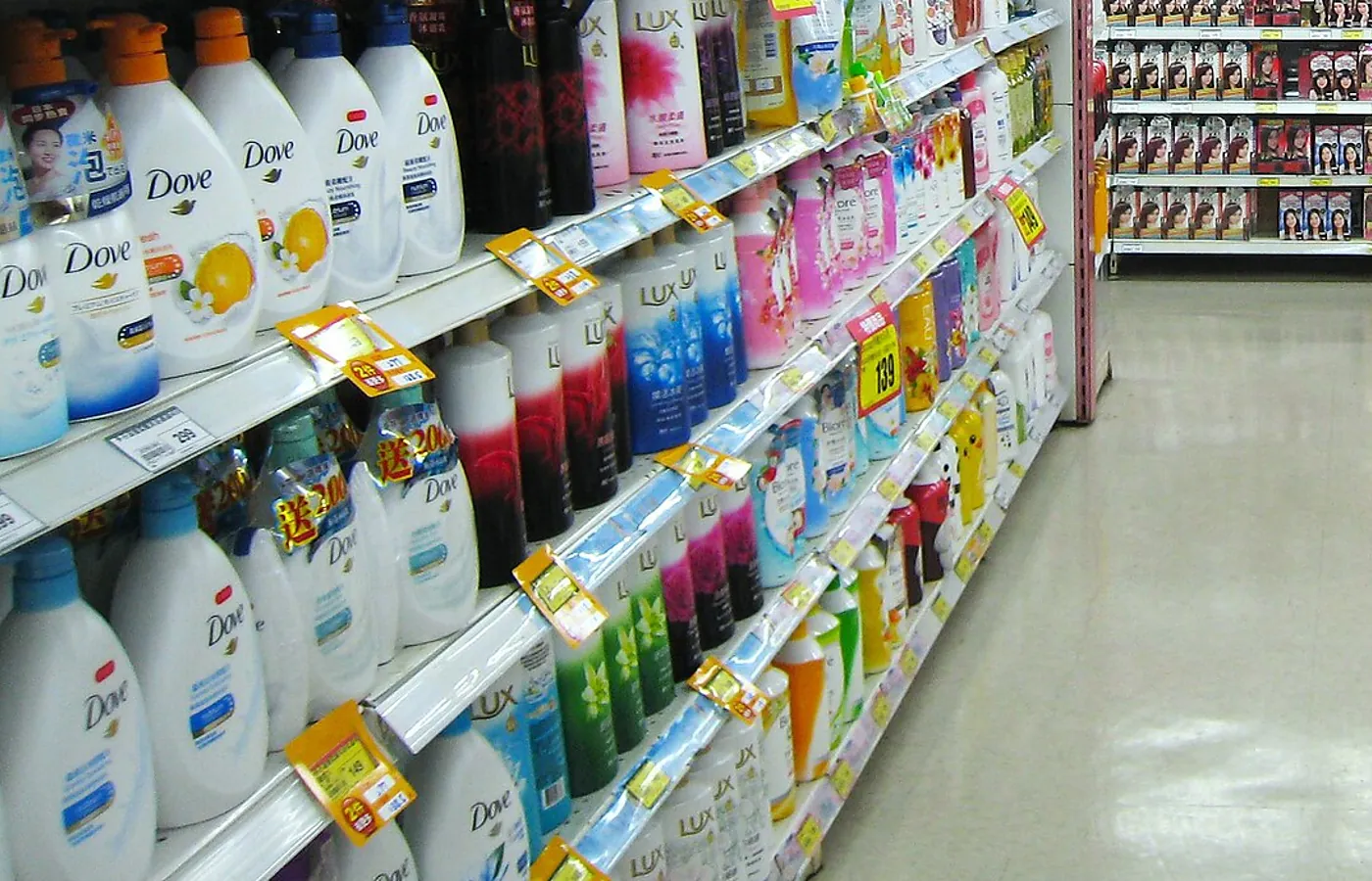 Supermarket personal care aisle with shelves stacked full of Dove body wash bottles.
