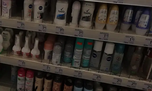 Long retail aisle lined with deodorant and antiperspirant packaging.