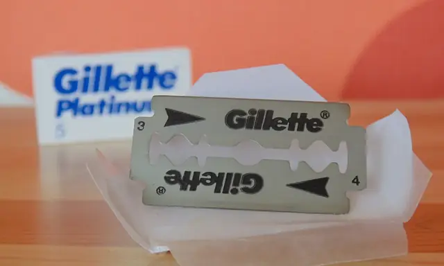 Gillette Platinum double-edge razor blade beside its paper wrapper and carton.